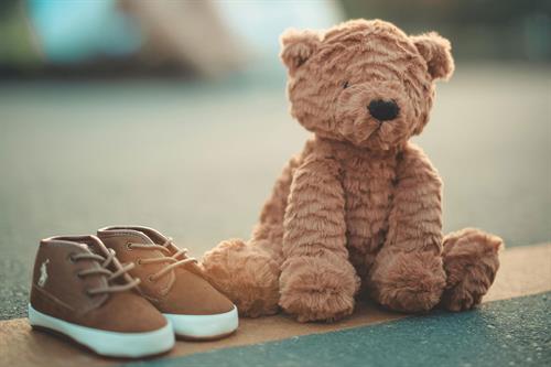 Ein Teddybär neben einem Paar Schuhe